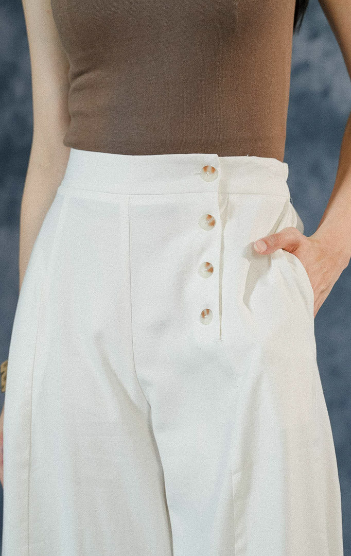 Celana kulot wanita Blakely warna ivory estetik dengan detail tekstur motif bercak unik, saku aktif, dan aksen 3 kancing di bagian samping celana.