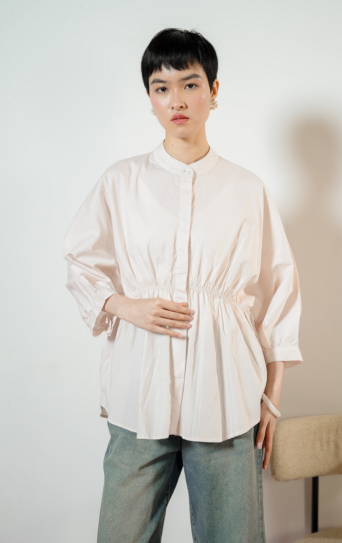 Detail dekat Ginera Ruched Waist Top warna pink, kemeja blouse wanita lengan panjang berwarna merah muda pucat dengan kerah sanghai dan detail kerut serut di pinggang. 