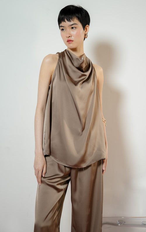 Detail dekat model mengenakan Wright Cowl Neck Satin Sleeveless Blouse warna taupe, atasan tank top wanita bahan satin kilap warna cokelat dengan detail kerah jatuh menjuntai anggun 