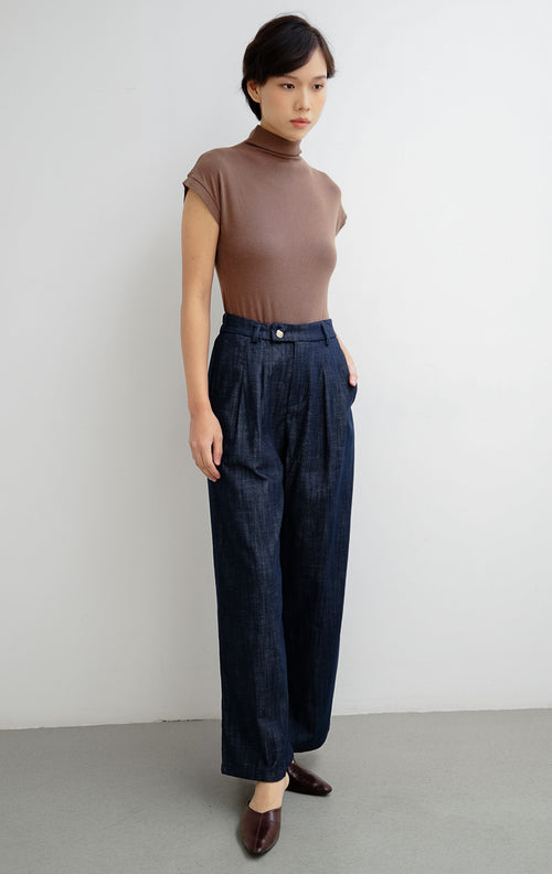 Celana panjang wanita warna biru navy Brielle Pants dengan potongan lurus (straight-cut), bahan katun slub bertekstur, dan aksen kancing emas di bagian depan.