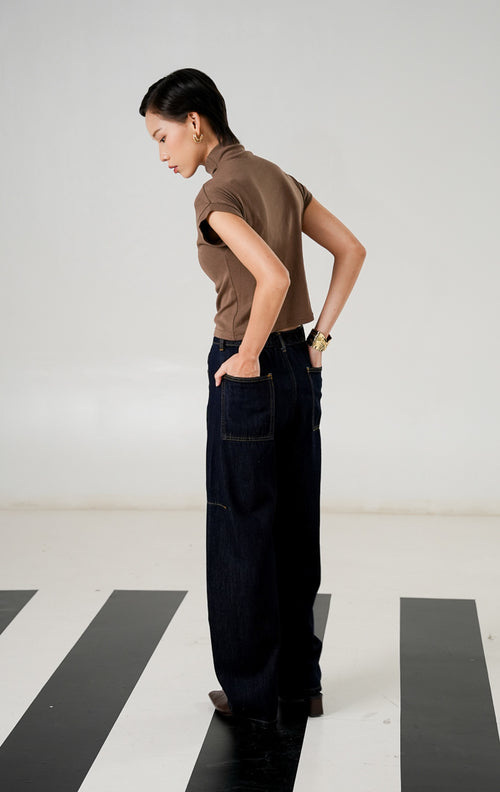 Celana jeans wanita Brion Barrel Pants warna Dark Denim dengan potongan kaki melengkung (barrel leg), detail jahitan kontras, dan karet pinggang belakang.