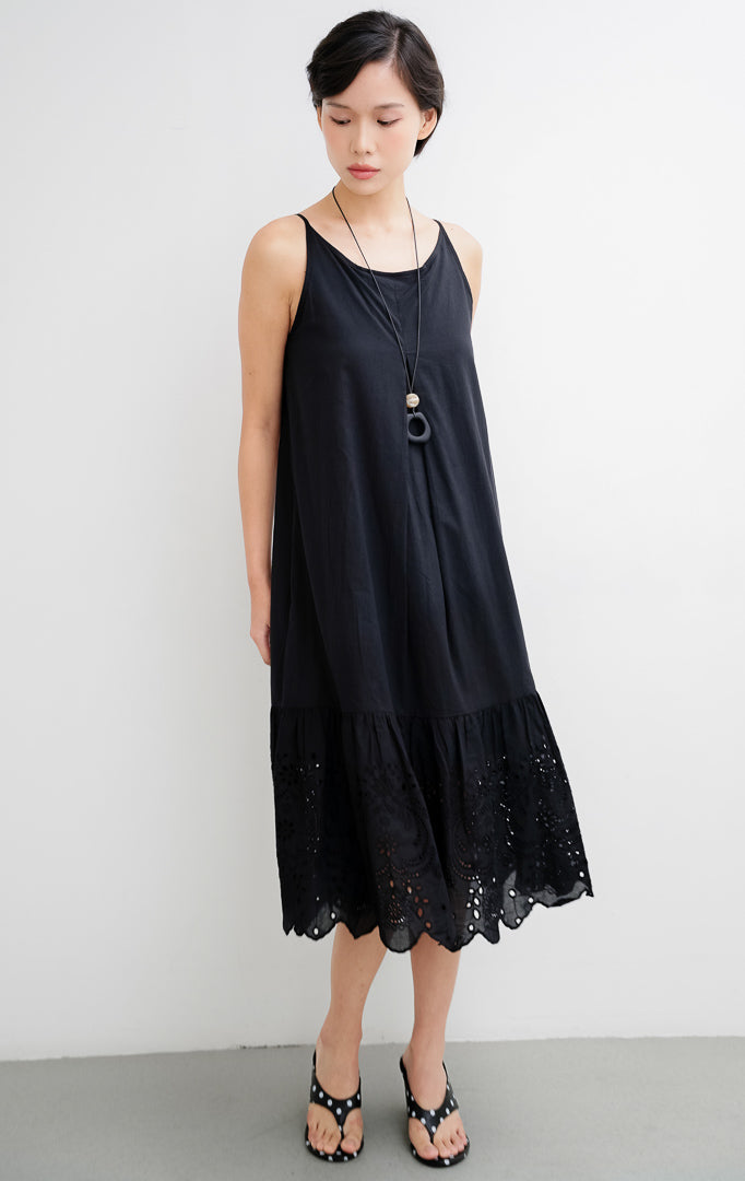 Dress midi wanita tanpa lengan (sleeveless) warna hitam Callia Dress berbahan katun adem dengan aksen bordir broderie cantik di bagian bawah hem.