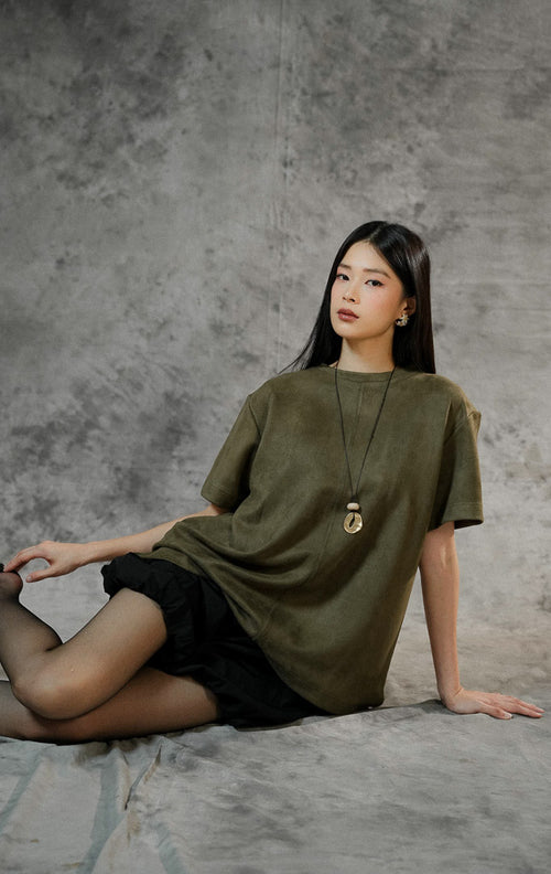 Baju atasan lengan pendek wanita Callidora warna army green berbahan suede lembut, potongan oversized, dengan detail belahan pendek di samping bawah.