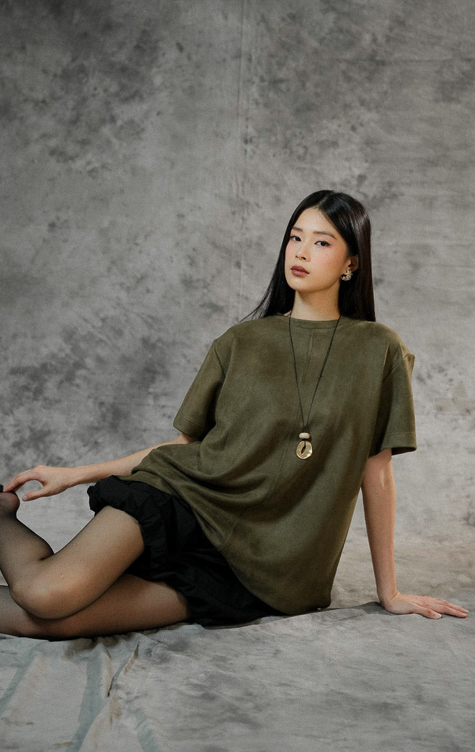 Baju atasan lengan pendek wanita Callidora warna army green berbahan suede lembut, potongan oversized, dengan detail belahan pendek di samping bawah.
