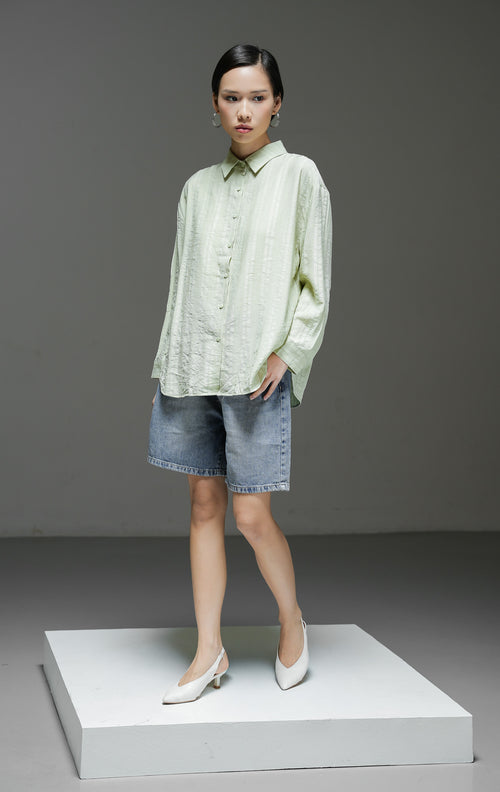Kemeja wanita Calliope Top warna hijau lengan panjang dengan motif garis tekstur (textured stripe), kerah kemeja, dan kancing depan. 