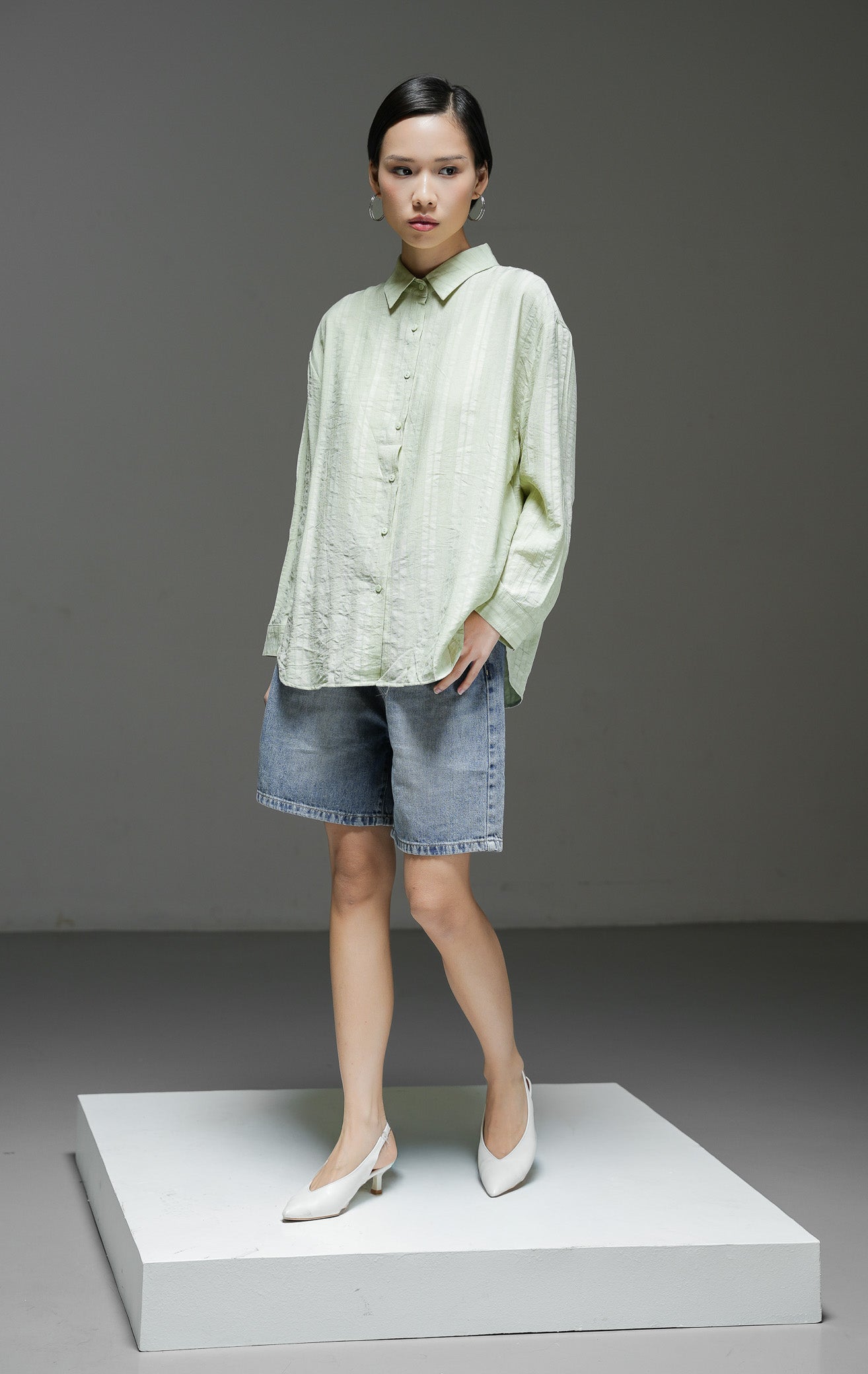 Kemeja wanita Calliope Top warna hijau lengan panjang dengan motif garis tekstur (textured stripe), kerah kemeja, dan kancing depan. 