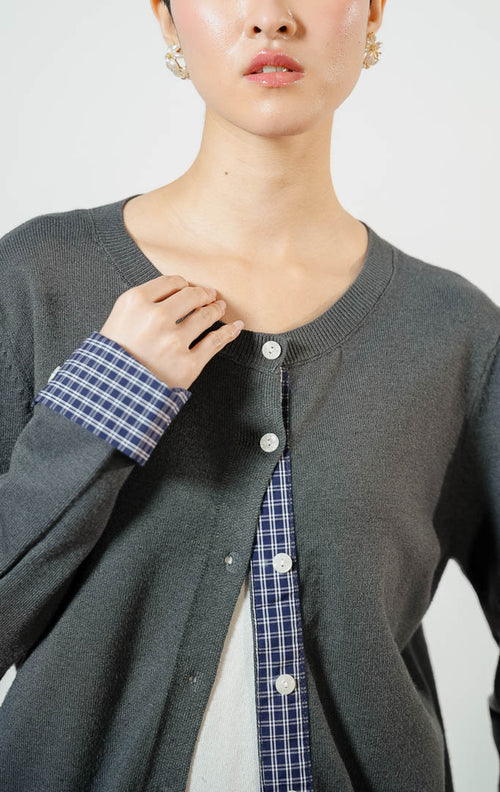 Model wanita mengenakan Kezia Flannel Sleeve Knit Cardigan warna grey, outer cardigan rajut wanita lengan panjang warna abu-abu dengan variasi aksen kain kotak-kotak flanel unik. 
