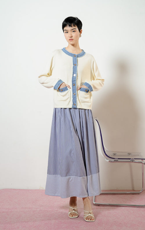 Model wanita mengenakan Peyton Outer warna ivory, baju cardigan rajut wanita warna putih gading dengan kombinasi aksen trim bahan jeans denim biru ber-rumbai.