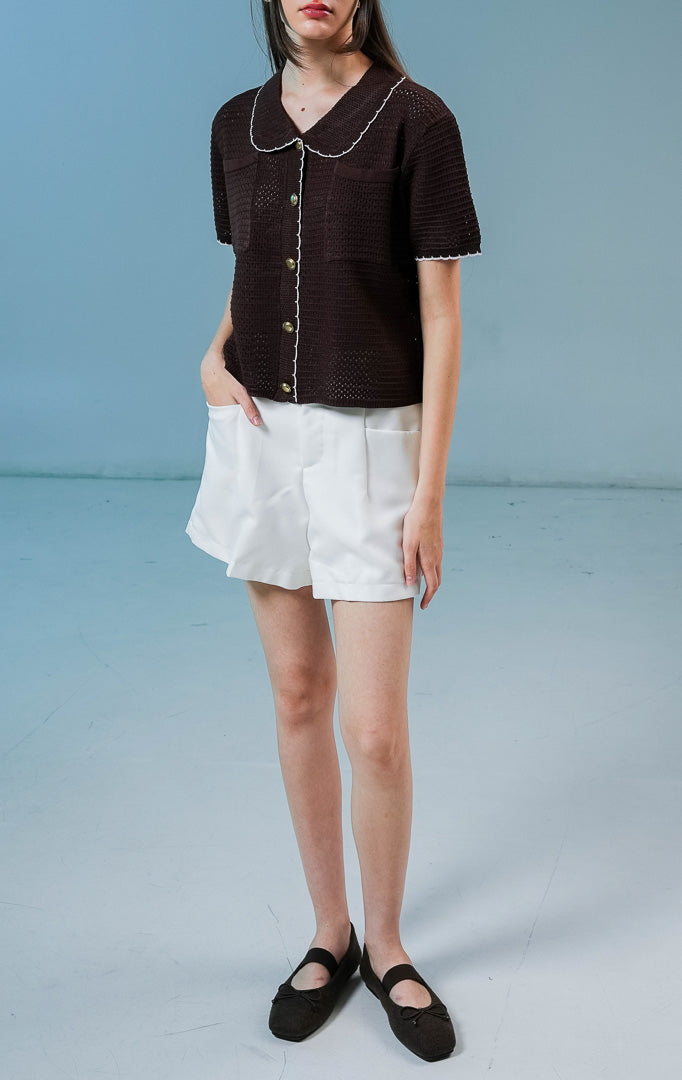 Model wanita mengenakan Mylah Pockets Knit Cardigan warna dark brown, luaran cardigan rajut wanita lengan pendek berwarna coklat tua dengan detail kerah dan kancing emas. 