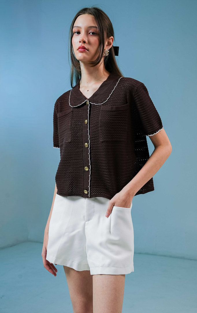 Model wanita mengenakan Mylah Pockets Knit Cardigan warna dark brown, luaran cardigan rajut wanita lengan pendek berwarna coklat tua dengan detail kerah dan kancing emas. 