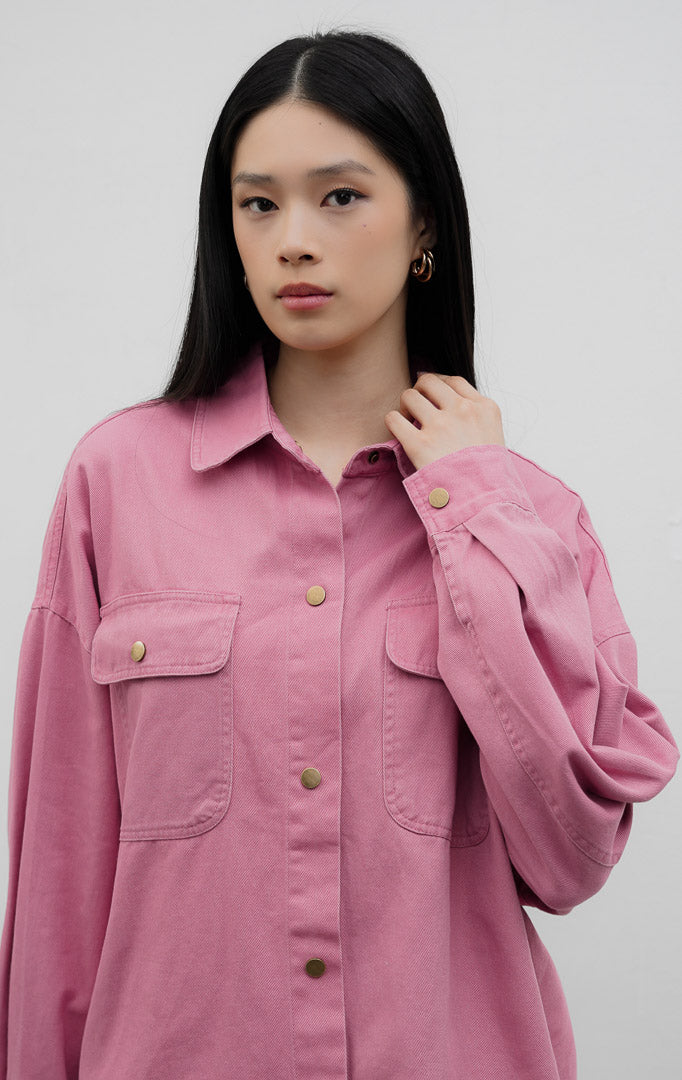 Jaket denim wanita potongan oversized warna merah muda (pink) Carmen Jacket berbahan denim dengan detail kancing jepret warna emas antik (rustic gold snap buttons) dan saku dada fungsional.