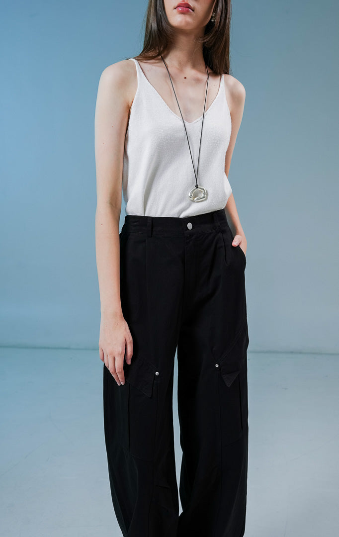 Model wanita mengenakan Lunaria Utility Straight Pants warna black, celana panjang cargo hitam wanita dengan siluet relaxed dan detail saku utilitas samping. 