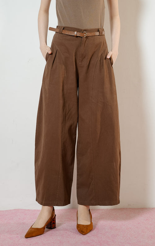 Detail dekat Regina Pants warna dark brown, celana panjang kulot kerja wanita warna cokelat tua dengan potongan pinggang tinggi dan detail jahitan panel melengkung yang unik. 