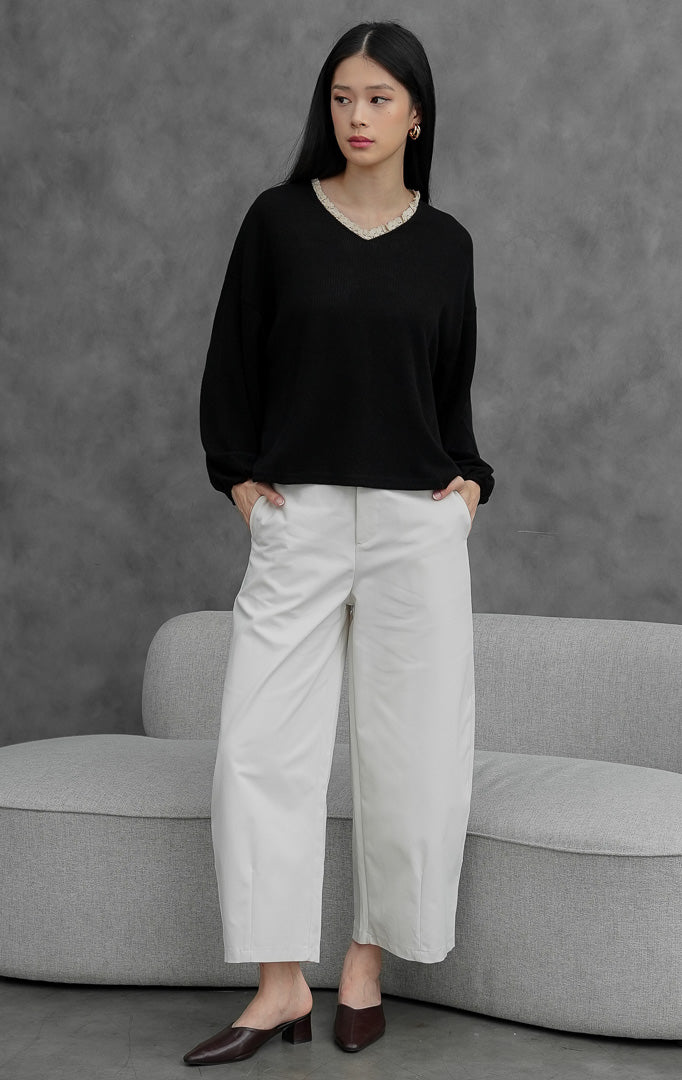 Sweter rajut wanita lengan panjang warna hitam (black) Chandria Sweater dengan potongan longgar (loose silhouette), lengan balon (balloon sleeves), dan aksen kerut renda kontras (contrast ruffle trim) di bagian leher.
