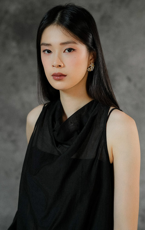 Blouse wanita tanpa lengan Charlette warna hitam polos dengan bahan transparan (sheer) yang elegan, cocok dipadukan dengan inner untuk look semi-formal.