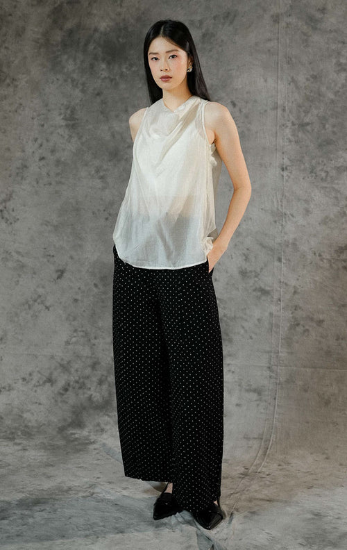 Atasan tanpa lengan wanita Charlette warna ivory dengan material poliester transparan (sheer finish) berdesain rapi dan kancing leher belakang.