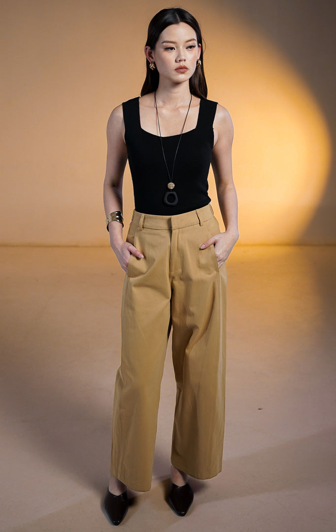 Model wanita memakai Christopher Pants Khaki, celana panjang bahan katun warna coklat muda dengan potongan barrel leg, saku samping, dan atasan hitam