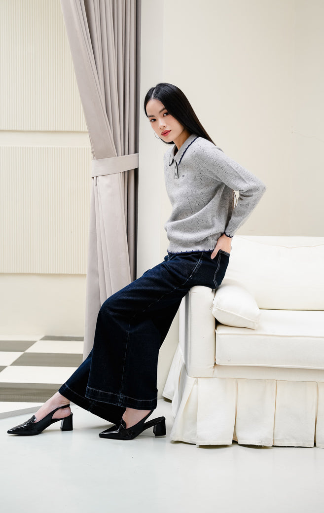 Baju rajut wanita Chrystie Sweater warna grey (abu-abu) motif pointelle dengan detail kerah lis kontras navy, kancing depan, serta bordir pita yang feminine. 