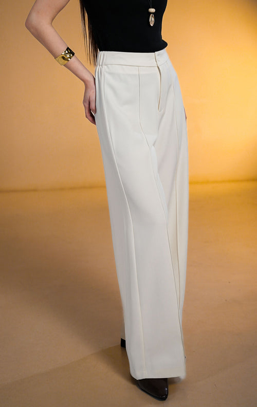 Model wanita memakai Clarence Pants White, celana panjang putih potongan lurus dengan detail jahitan tulang depan (front darts) dan pinggang karet