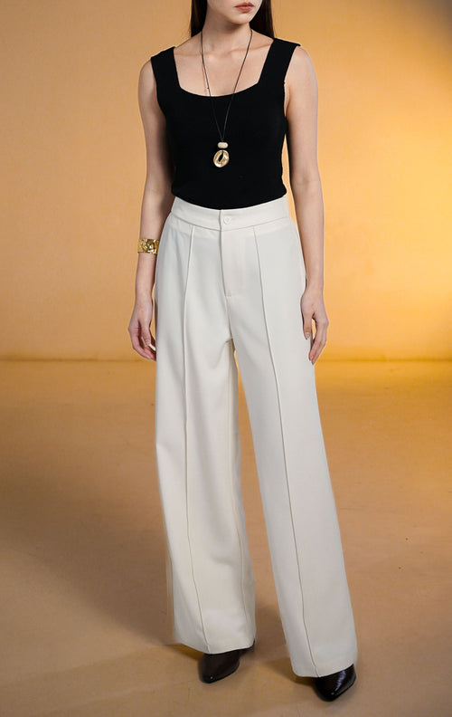 Model wanita memakai Clarence Pants White, celana panjang putih potongan lurus dengan detail jahitan tulang depan (front darts) dan pinggang karet