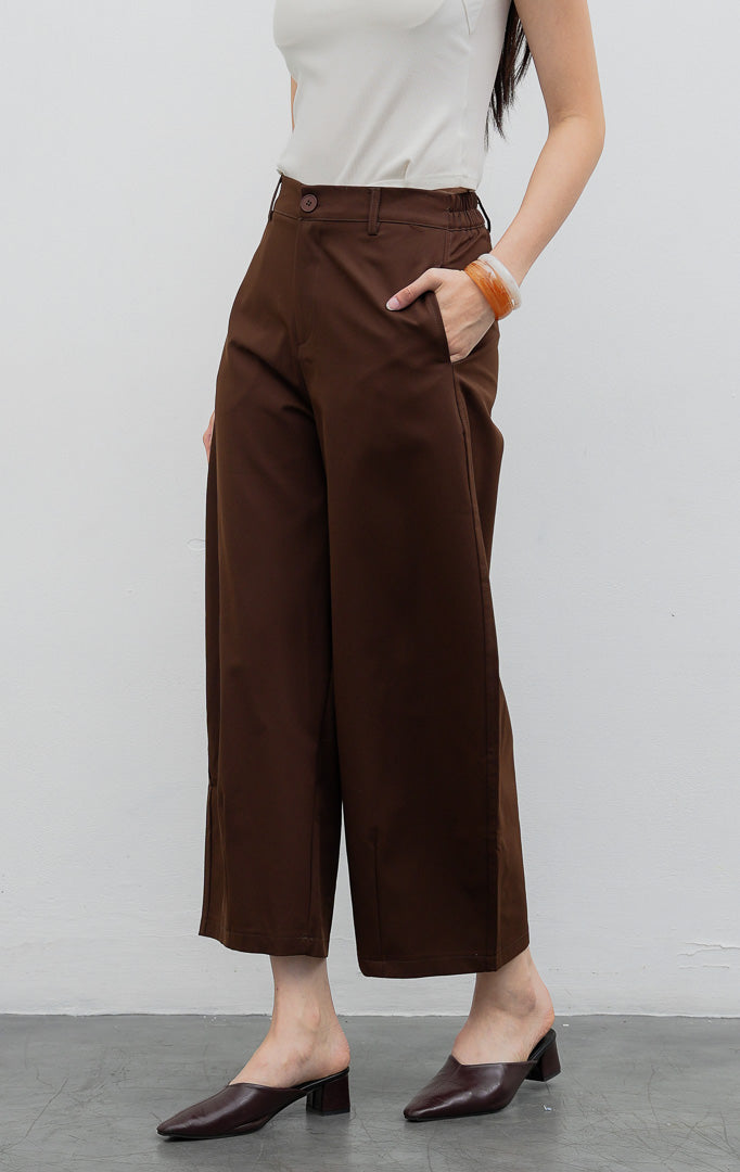 Celana panjang wanita model lurus (straight leg) warna cokelat tua (dark brown) Coletta Pants berbahan cotton twill terstruktur dengan saku fungsional, bukaan kancing depan, dan belt loops.