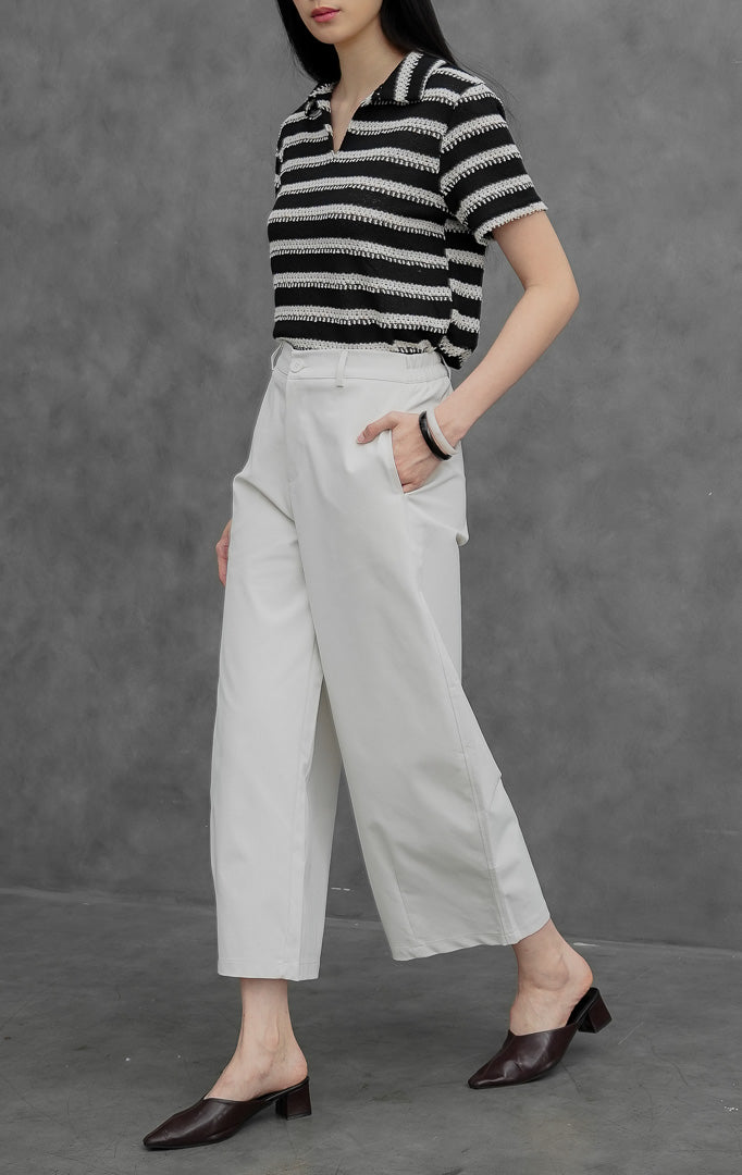 Celana panjang wanita model lurus (straight leg) warna krem muda (ivory) Coletta Pants berbahan cotton twill terstruktur dengan saku fungsional, bukaan kancing depan, dan belt loops.