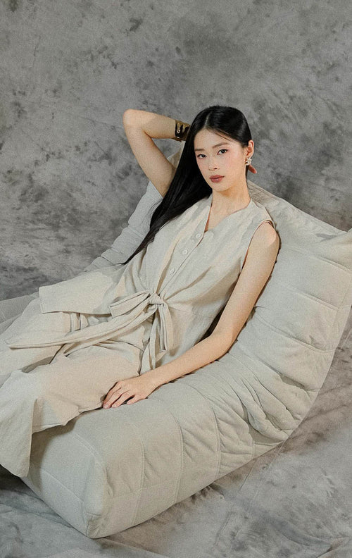 Setelan baju wanita Collette warna khaki polos terdiri dari atasan tanpa lengan dengan tali pita depan dan celana panjang dengan kancing resleting.

