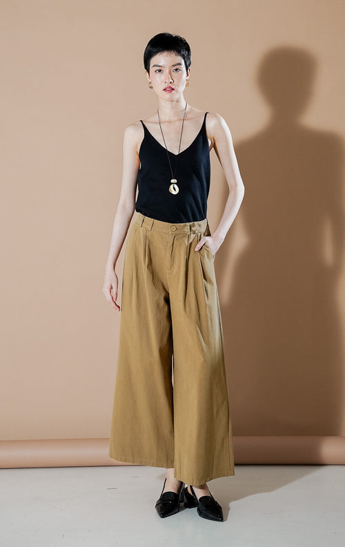 Model wanita mengenakan Credence Pants Khaki, celana kulot lebar (wide leg) dengan detail lipit depan dan potongan high waist yang elegan dari This Is April.