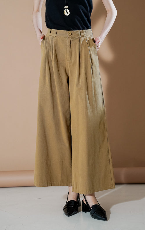 Model wanita mengenakan Credence Pants Khaki, celana kulot lebar (wide leg) dengan detail lipit depan dan potongan high waist yang elegan dari This Is April.