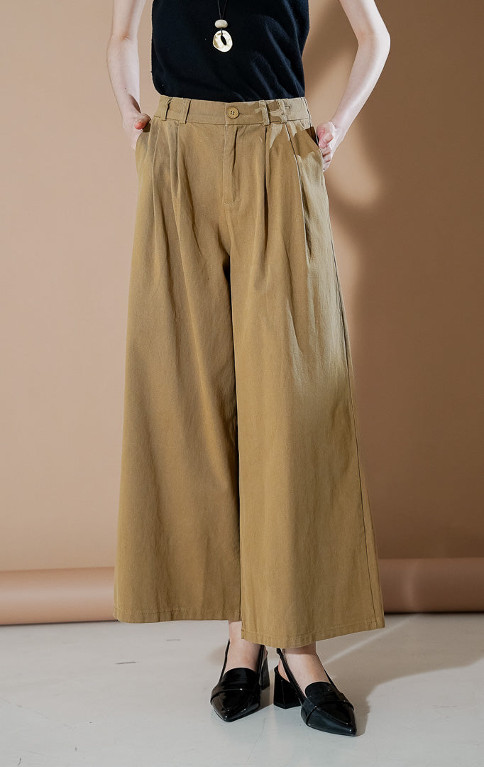 Model wanita mengenakan Credence Pants Khaki, celana kulot lebar (wide leg) dengan detail lipit depan dan potongan high waist yang elegan dari This Is April.