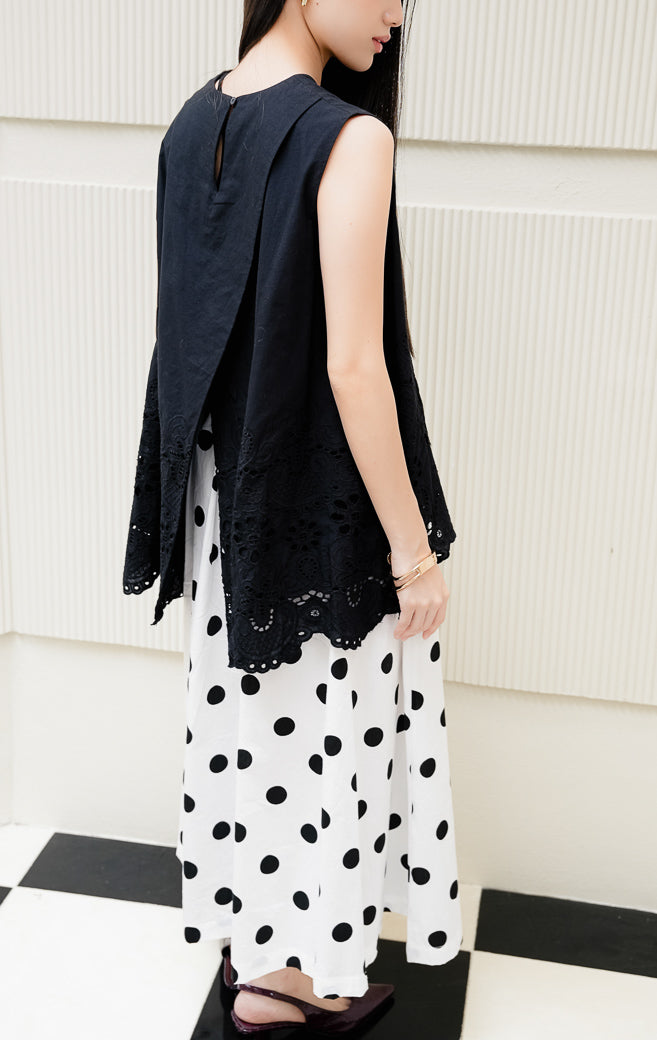 Atasan blouse tanpa lengan wanita warna hitam Cyrus Top dengan detail bordir krawang broderie anglaise di bagian bawah dan kancing belakang. 