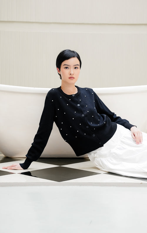 Cardigan rajut lengan panjang wanita warna hitam Daimen Top dengan aksen manik mutiara berkilau (rhinestone), kerah bulat (round-neck), dan kancing depan.