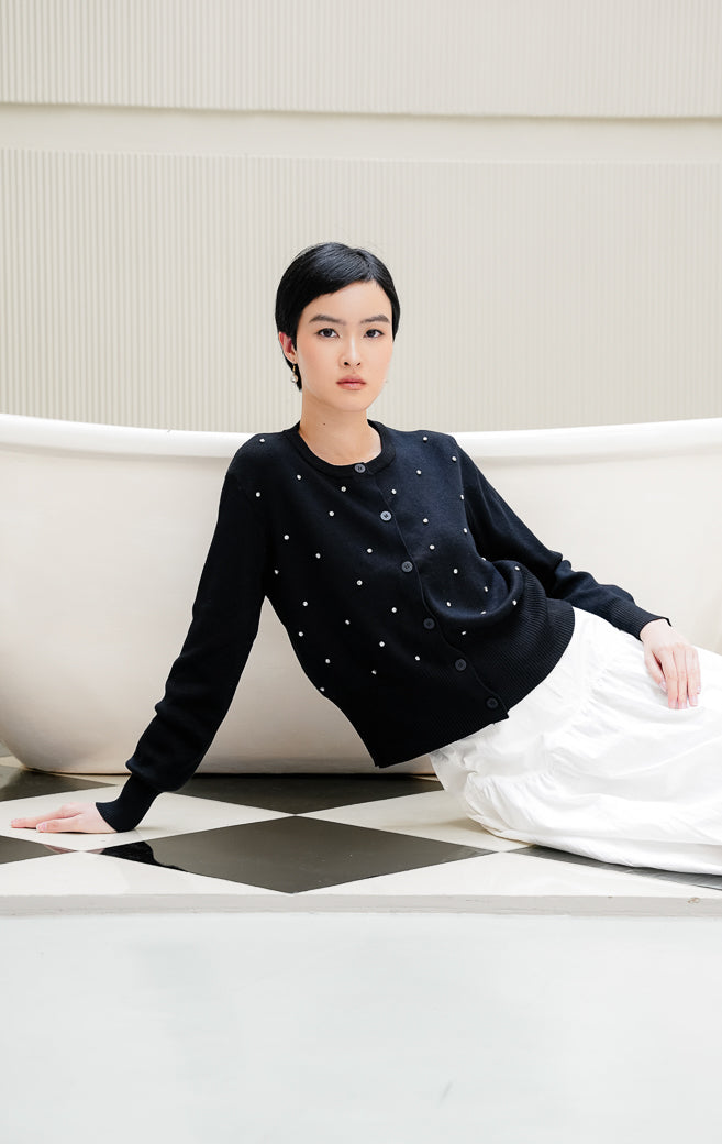 Cardigan rajut lengan panjang wanita warna hitam Daimen Top dengan aksen manik mutiara berkilau (rhinestone), kerah bulat (round-neck), dan kancing depan.