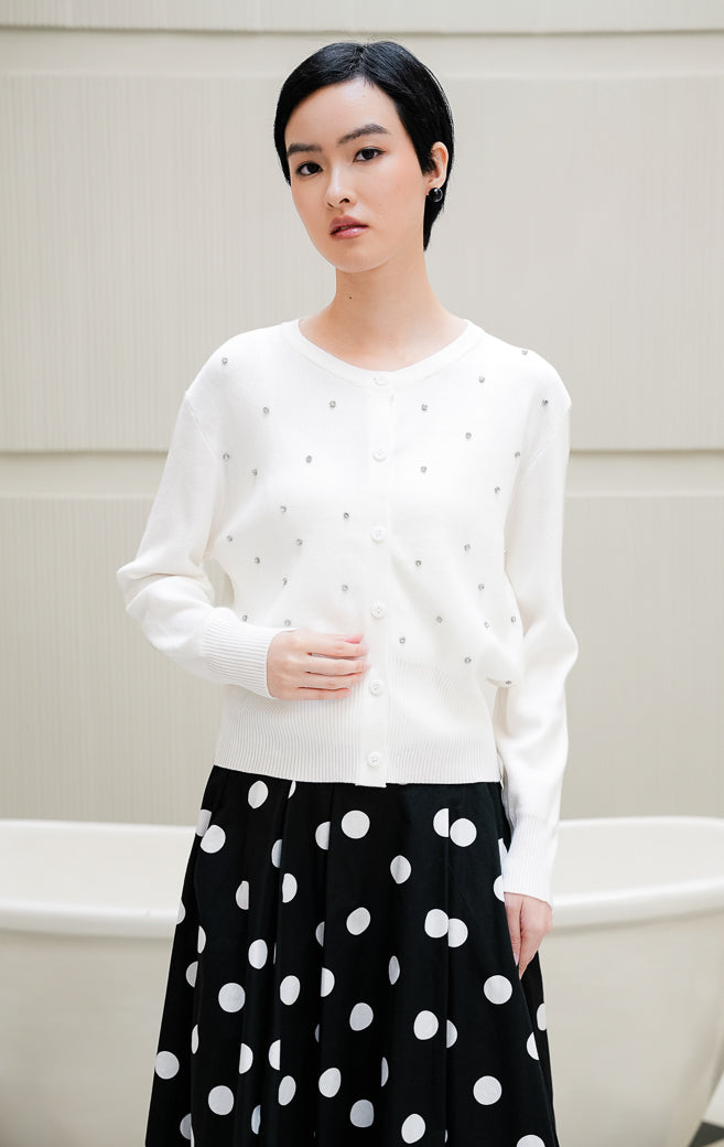 Cardigan rajut lengan panjang wanita warna putih Daimen Top dengan aksen manik mutiara berkilau (rhinestone), kerah bulat (round-neck), dan kancing depan.