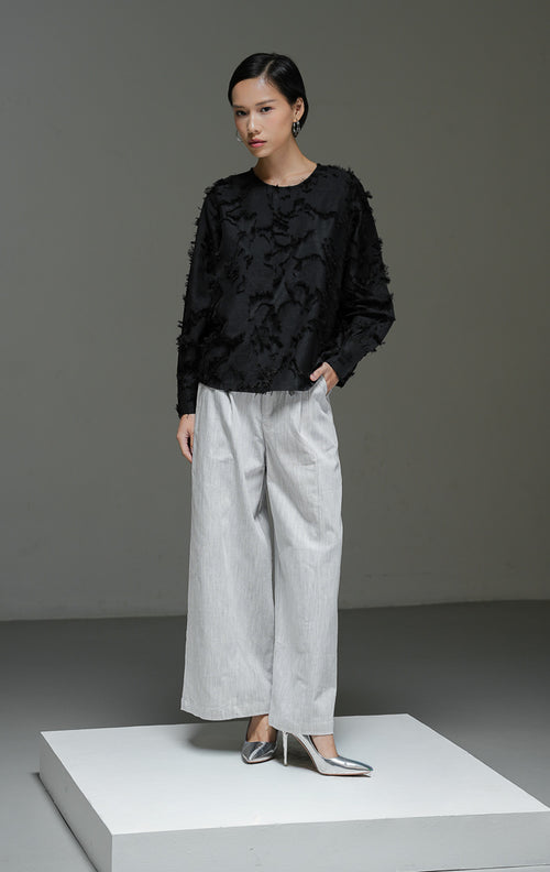 Blouse wanita Demetrius Top warna hitam lengan panjang dengan tekstur bulu halus (fringe jacquard), kerah bulat, dan kancing belakang. 