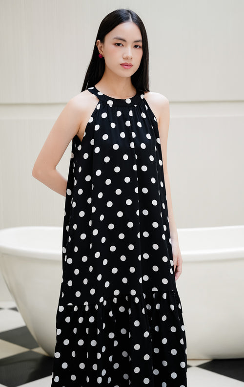 Dress wanita tanpa lengan motif polkadot warna hitam Domino Dress dengan model kerah halter, detail lipatan (gathered), dan kancing belakang
