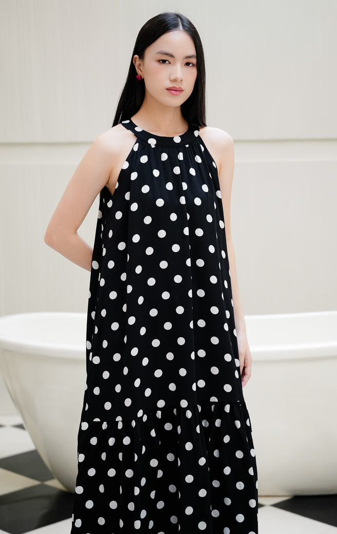 Dress wanita tanpa lengan motif polkadot warna hitam Domino Dress dengan model kerah halter, detail lipatan (gathered), dan kancing belakang