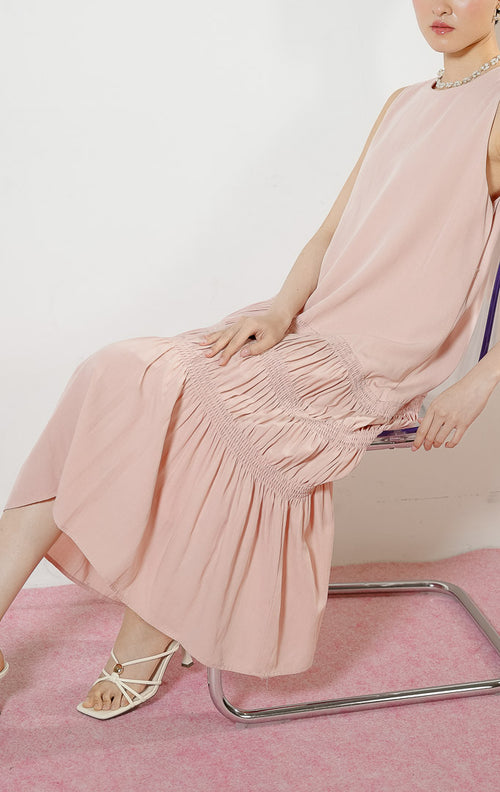 Model wanita mengenakan Ravena Shirred Bodice Drop-Tier Maxi Dress warna pink, gaun panjang dress tanpa lengan wanita warna merah muda dengan detail aksen serut karet smok miring bertingkat di rok. 