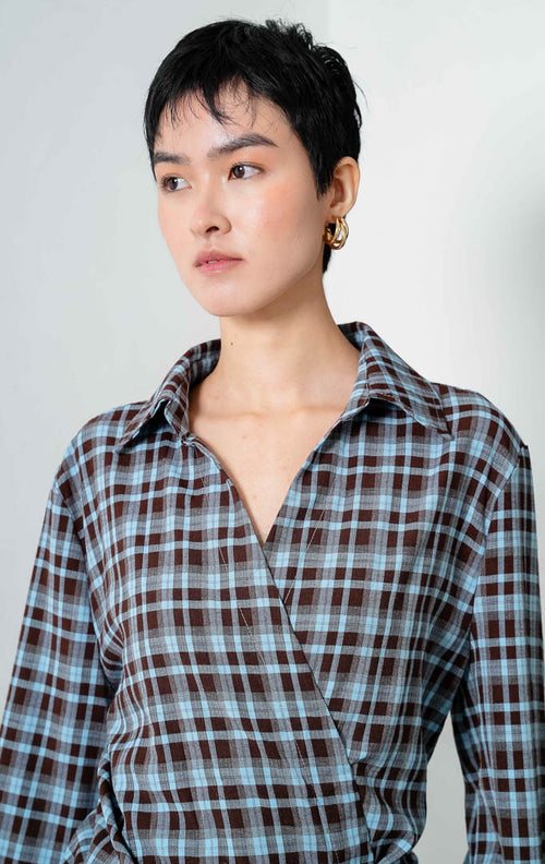 Kemeja wanita lengan panjang motif kotak-kotak cokelat tua (dark brown checked) Druella Top model siluet silang (v-neck wrap shirt) dengan detail tali pengikat dan kancing di bagian dalam (inner tie and button detail). 