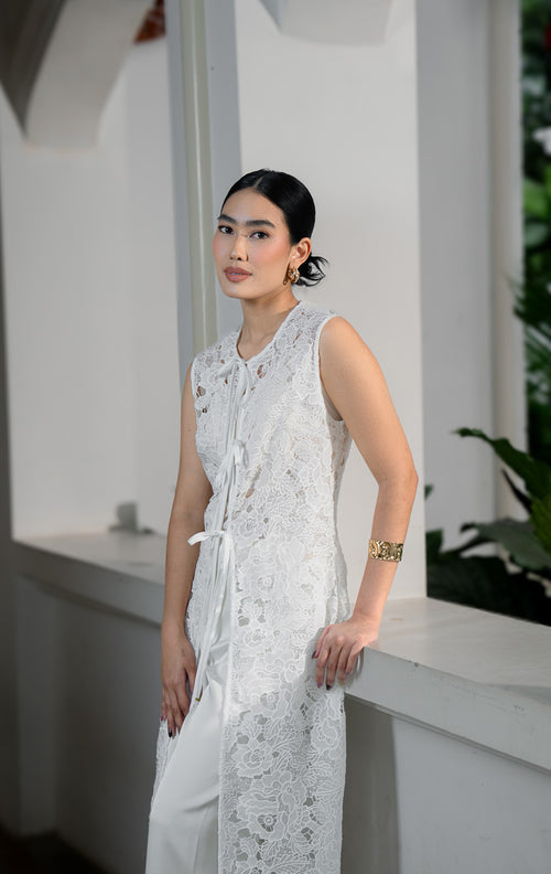 EID Aziza Top White, luaran rompi panjang wanita bahan lace brukat 
transparan warna putih dengan motif bunga dan detail tali pengikat pita di 
bagian depan.
