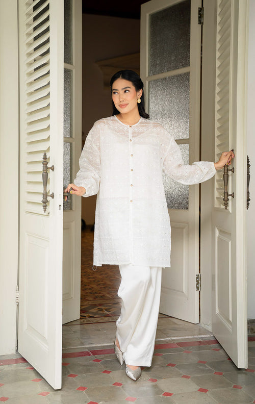 EID Garini Outer Ivory, atasan tunik wanita bahan cotton voile warna putih 
gading dengan motif bordir eyelet geometris horizontal dan deretan 
kancing emas depan