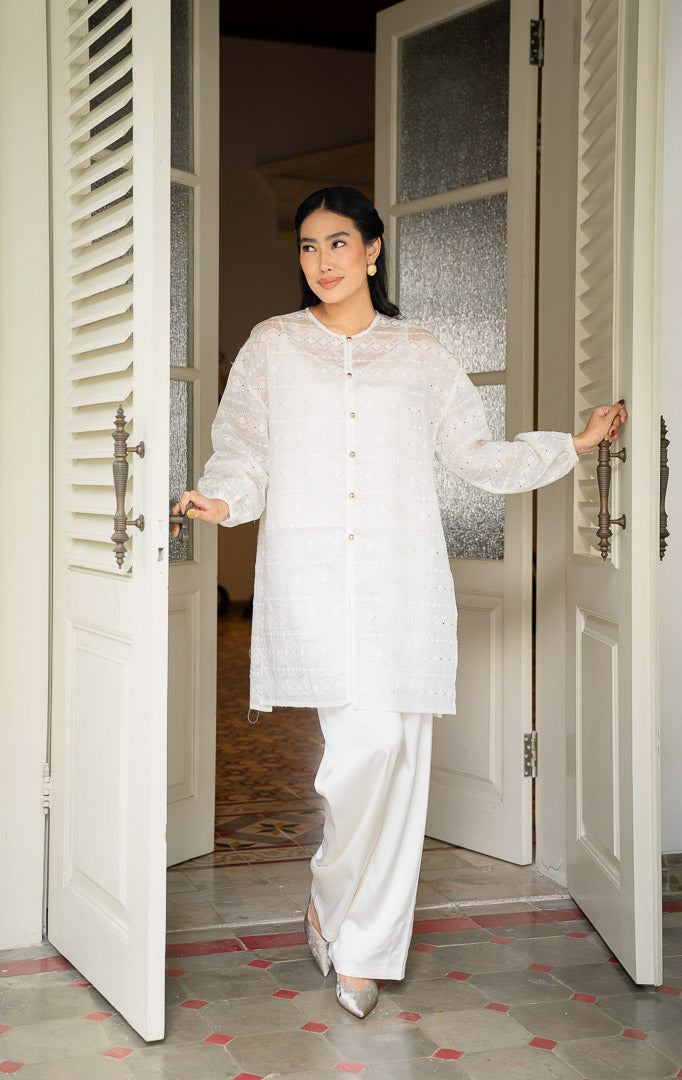 EID Garini Outer Ivory, atasan tunik wanita bahan cotton voile warna putih 
gading dengan motif bordir eyelet geometris horizontal dan deretan 
kancing emas depan