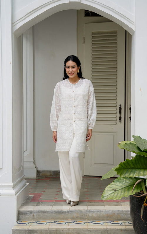 EID Garini Outer Ivory, atasan tunik wanita bahan cotton voile warna putih 
gading dengan motif bordir eyelet geometris horizontal dan deretan 
kancing emas depan