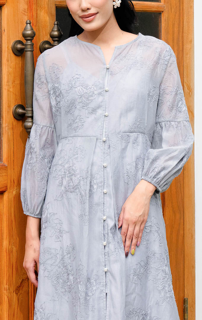 EID Isra Dress Grey, gamis panjang wanita warna abu abu bahan cotton 
voile dengan motif bordir bunga penuh, lengan balon, dan kancing depan 
mutiara.