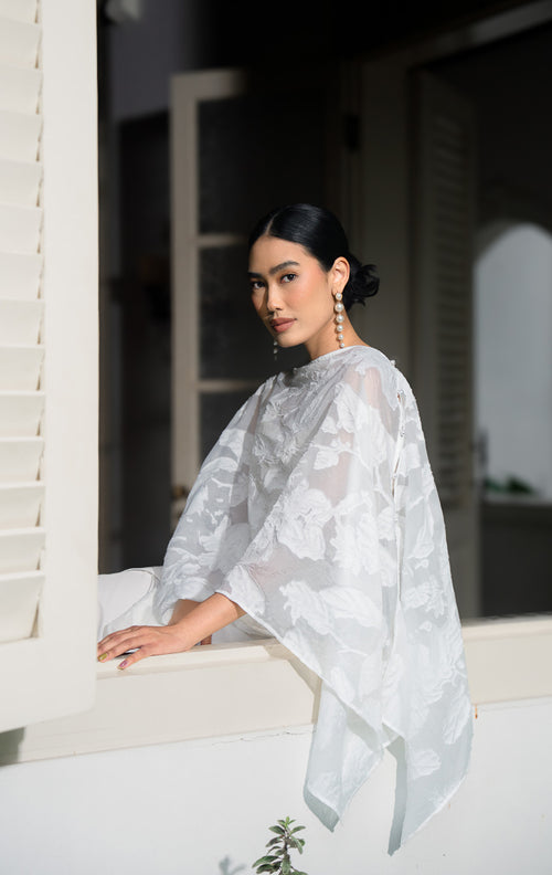 EID Jina Outer White, luaran model cape wanita bahan organza jacquard 
warna putih bersih dengan motif bunga timbul 3D dan detail kancing di 
bahu