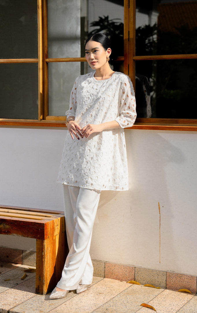 EID Latifa Top White, atasan wanita warna putih bersih bahan katun dengan 
motif bordir eyelet berlubang dan detail kancing mutiara miring asimetris di 
depan.