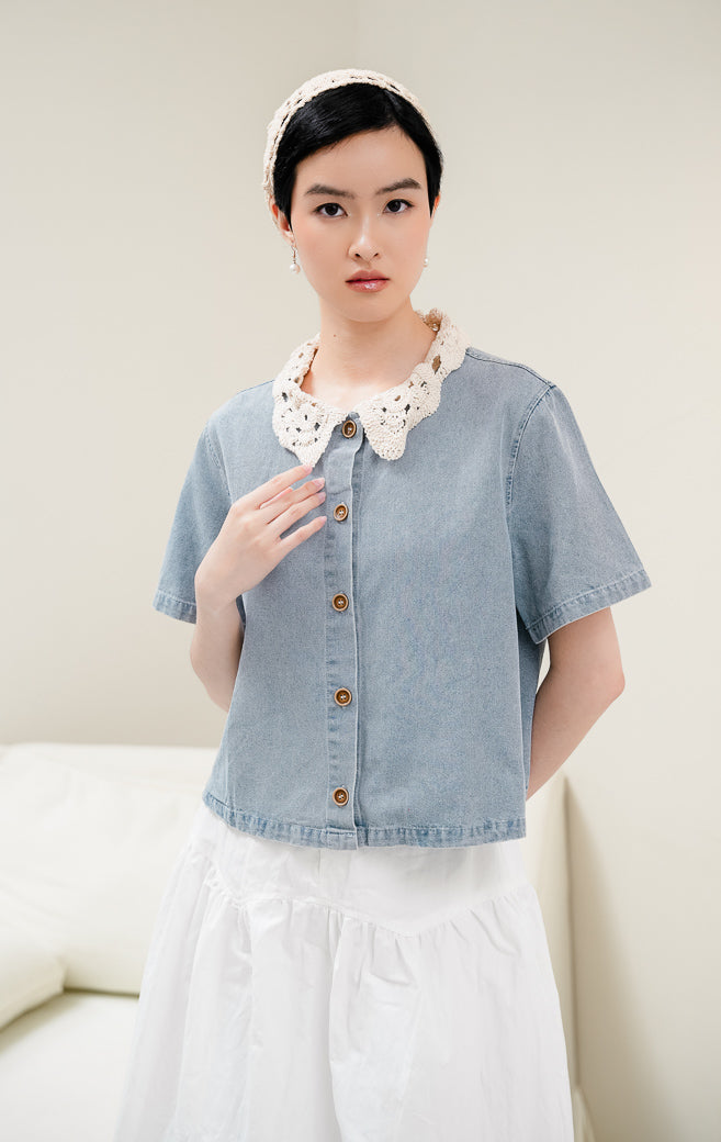 Atasan kemeja denim wanita Elliana Top warna light denim (biru muda) berbahan denim terstruktur dengan detail kerah renda (crochet collar) dan kancing depan style feminine & vintage.