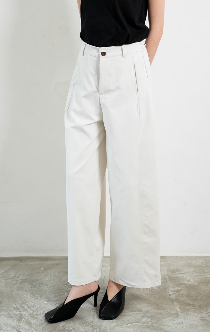 Celana panjang wanita potongan lurus warna putih (white straight-cut long pants) Emmanuel Pants dengan siluet minimalis yang bersih (clean minimal silhouette), ban pinggang berstruktur dengan kancing, dan tampilan serbaguna yang elegan (polished structured shape).
