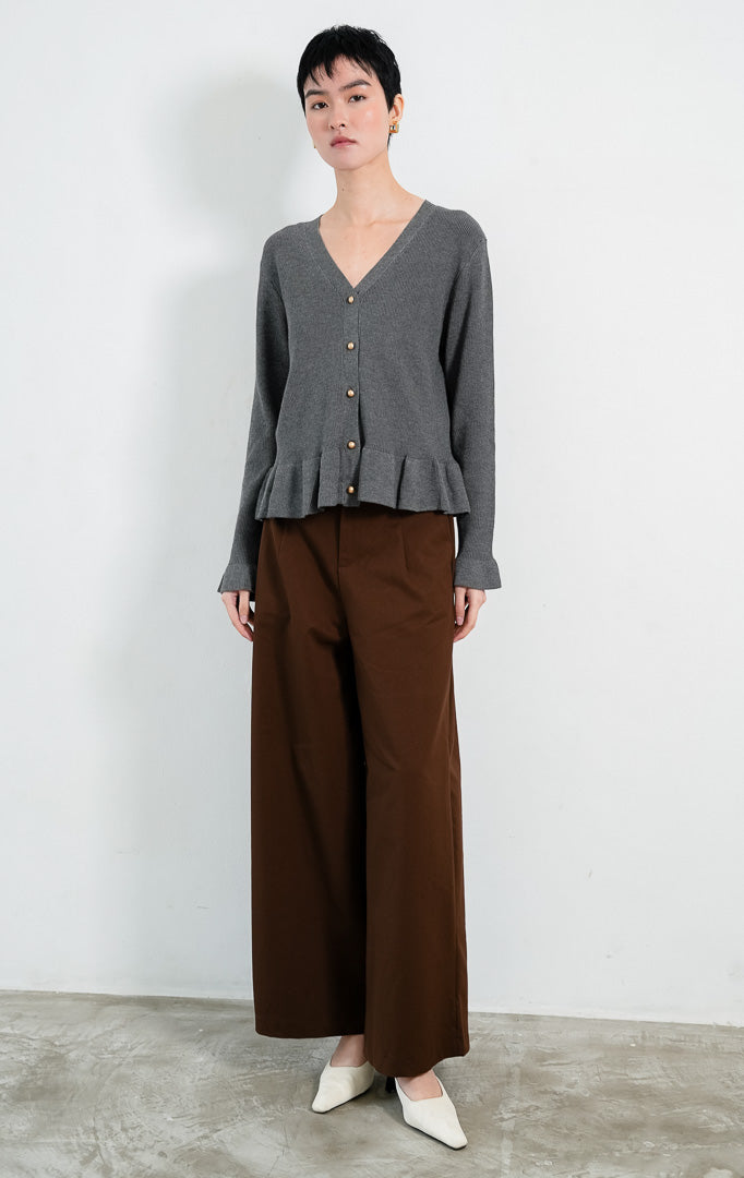 Kardigan rajut wanita lengan panjang warna abu-abu tua (dark grey) Eugenia Cardigan berstruktur knit dengan potongan pinggang mekar (peplum silhouette), leher V (V-neckline), dan kancing emas (gold-tone buttons). 