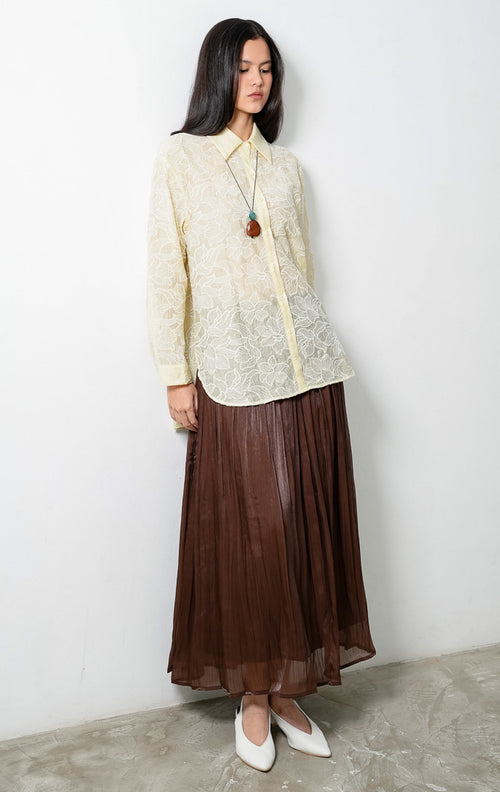 Kemeja wanita lengan panjang warna kuning muda (butter yellow) Everlynne Top berbahan tekstur ringan (lightweight textured fabric) dengan kerah kemeja (collared neckline), bukaan kancing depan, dan detail bordir motif bunga (tonal floral embroidery). 

